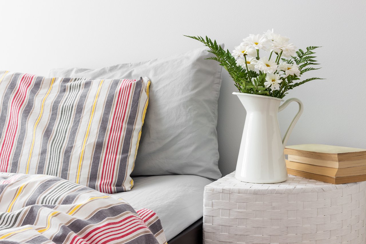 White flowers and books on a bedside table
